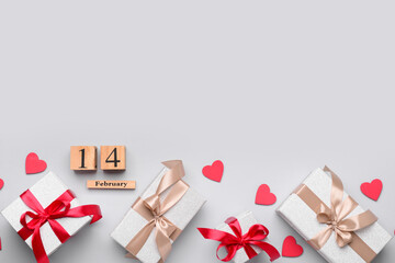 Cube calendar with date 14 FEBRUARY and gift boxes for Valentine's Day celebration on white background