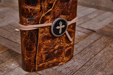Vintage Leather Journal with Cross Emblem on Wooden Table