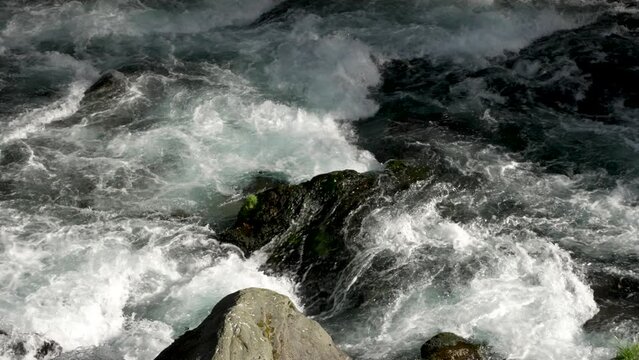 Water stream flows through the stones, in slow motion. Location the Daiya River in Nikko, Japan, where the gentle flow of water harmonizes with the natural beauty of the surroundings.