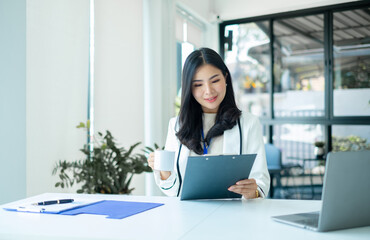 Asian businesswoman sit at their desks and calculate financial graphs showing results about their...