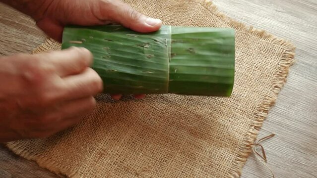 a man's hands unwrapping tempeh vegan food