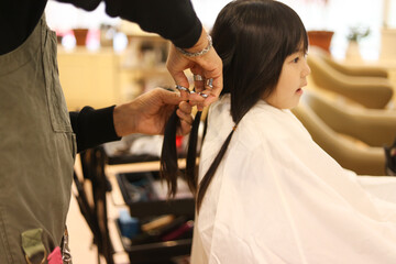美容室で髪の毛を切る女の子　ヘアドネーションイメージ