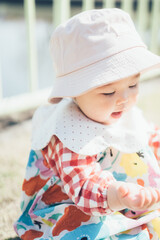 公園で帽子を被る赤ちゃん