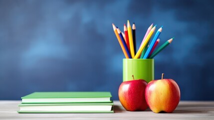 School education themed photo, stack of books pencils pens and apples on the table, with a blackboard background.