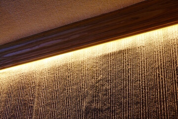 Luxurious Golden Wall Feature with Textured Backdrop and Ambient Light