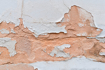 Abstract background of cracked concrete wall with peeling paint.