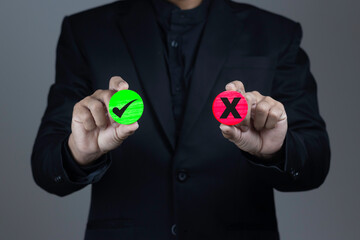 Businessman holds circle stick with right and wrong marks for selection concept.