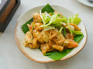 Stir-fried squid with salted egg sauce, put on a saucer with banana leaf and ready to serve.