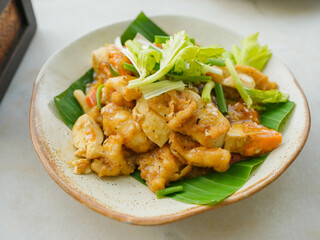 Stir-fried squid with salted egg sauce, put on a saucer with banana leaf and ready to serve.