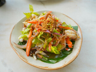 Seafood Glass Noodle Salad Famous Thai food served on a plate with vegetables.
