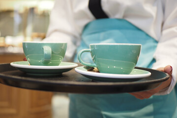 Waitress offering a cup of coffee.