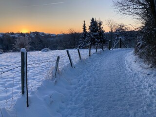 Sonnenaufgang in winterlicher Landschaft mit Schnee vom Feldweg ausgesehen