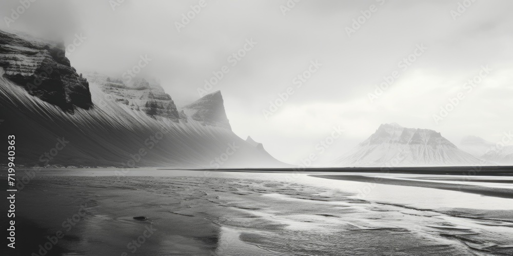 Poster A monochrome image of a serene beach with majestic mountains in the backdrop. Suitable for various uses