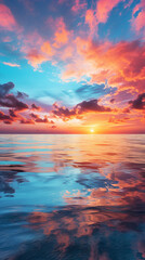 Fototapeta premium Sunset over the sea with clouds and sky reflected in the water