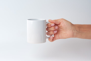 Female hand holding coffee mug against white background