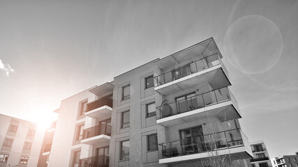 Fragment of the building's facade with windows and balconies. Modern apartment buildings on a sunny day. Facade of a modern residential building. Black and white.