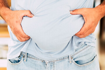Caucasian fat man hold his belly with hands - diet and healthy lifestyle concept - junk food...