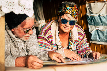 Happy old senior couple enjoy the together travel in old vehicle vintage van - concept of changing...