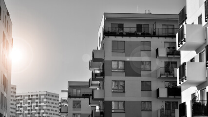 Fragment of the building's facade with windows and balconies. Modern apartment buildings on a sunny day. Facade of a modern residential building. Black and white.