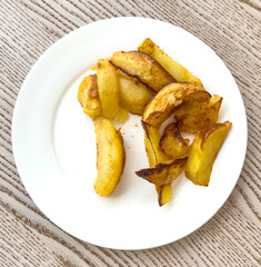 Fried potatoes in a white plate on the table