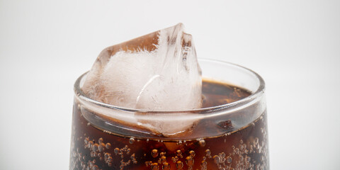 Cola in a glass with ice close up isolated.
