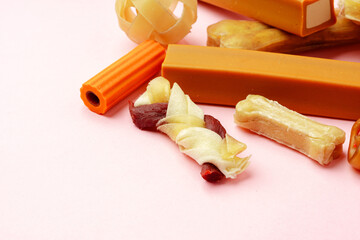Dog chew bone and sticks on pink background