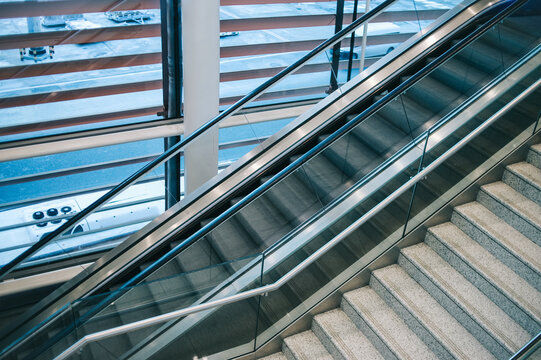 Modern escalator beside the stairway
