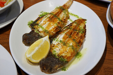 Close up plate of grilled fish filet with lemon- Spanish Tapas