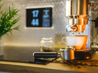 Home kitchen. Coffe cup next to espresso machine. Smart home display.