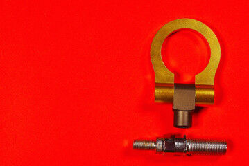 Sport car tow hook on the red flat lay background close up with copy space.