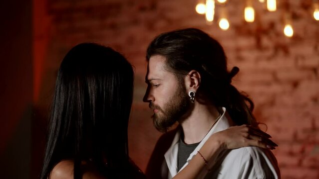 passionate lovers dancing sexually and hugging each other, medium shot, woman embracing man