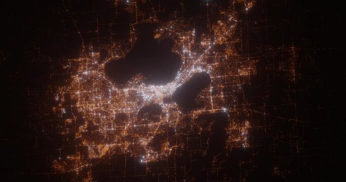 Madison (Wisconsin, USA) aerial view at night. View on modern city from space. Camera is zooming in, rotating counterclockwise