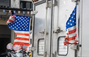 Tattered US flags fly on a moving truck