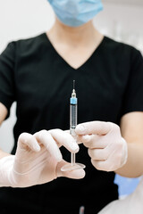 A female cosmetologist in gloves is preparing to give a young woman a cosmetological procedure. Modern dermatology clinic, cosmetic procedures and cosmetic surgery