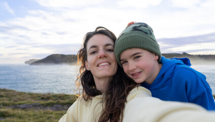 Mother and son taking a selfie with the sea in the background