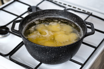 Cooking potato in a pot with boiling water on a gas stove