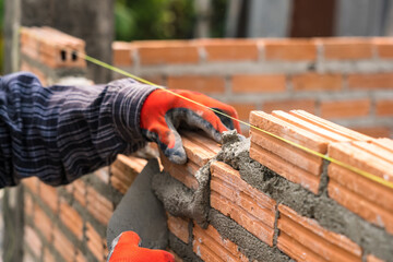 Hand worker masonry brickwork trowel construction site wall concrete background - 720051128
