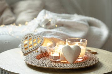 Home composition for Valentine's Day with candles in the interior of the room.