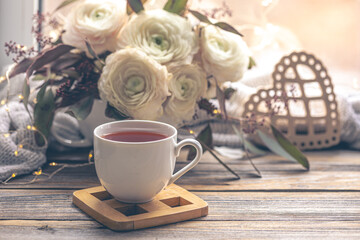Cozy home composition with a cup of tea and flowers.