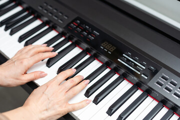 keyboard and hands playing the piano