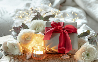 Romantic composition with gift box, flowers and candle.