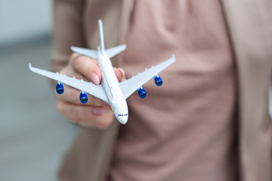 Female woman hands holding small toy model plane. Travel by plane vacation weekend adventure trip journey ticket tour aviation delivery concept. Symbol of international freedom