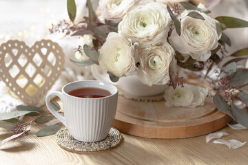 Festive still life with flowers, cup of tea and decorative heart.