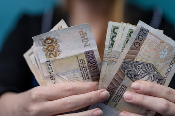 Kobieta wydaje pieniądze, gotówka polska pln w dłoniach  - obrazy, fototapety, plakaty