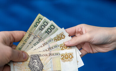 Wręczać komuś pieniądze, polskie banknoty pln przekazywane z rąk do rąk  - obrazy, fototapety, plakaty