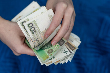 Kobieta trzyma w dłoniach pieniądze, liczy polskie banknoty - obrazy, fototapety, plakaty