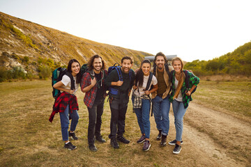 Group portrait of cheerful joyful smiling hikers in nature. Team of happy young friends with hiking...