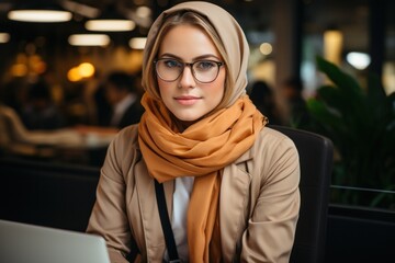 A cute and attractive businesswoman in a headscarf with a laptop, exuding confidence and professionalism.