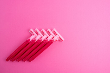 Pink women's razors isolated on yellow and pink background. Pink women's disposable razors. Skin and body care concept. Depilation. Place for text