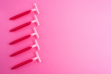Pink women's razors isolated on yellow and pink background. Pink women's disposable razors. Skin and body care concept. Depilation. Place for text
